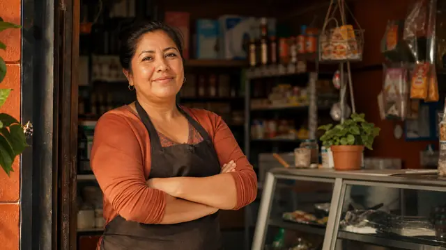 Dueña de una tienda de abarrotes en la puerta de su local
